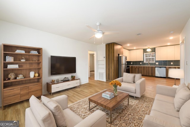 living room featuring a ceiling fan, recessed lighting, light wood-style flooring, and visible vents
