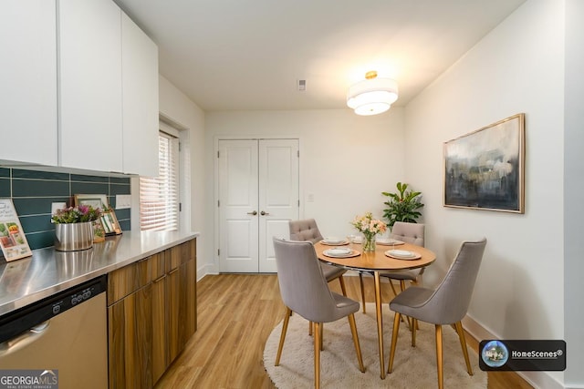 dining room featuring light wood-style floors and baseboards