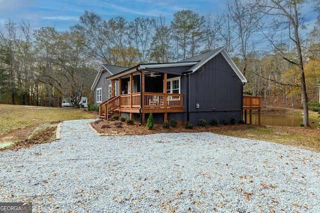 view of front of property with a porch, a ceiling fan, and roof with shingles