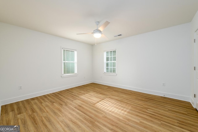 unfurnished room featuring a ceiling fan, baseboards, visible vents, and light wood-style floors