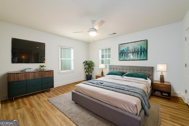 bedroom featuring a ceiling fan, baseboards, visible vents, and light wood-type flooring
