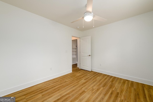 spare room with light wood-style floors, baseboards, and ceiling fan