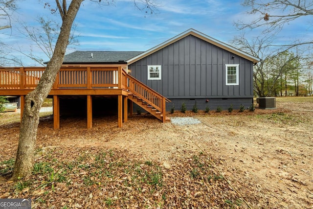 back of property featuring board and batten siding, roof with shingles, a deck, stairway, and cooling unit