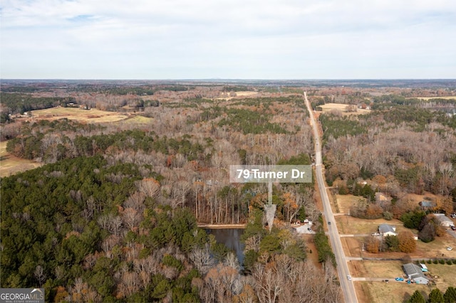 bird's eye view with a wooded view