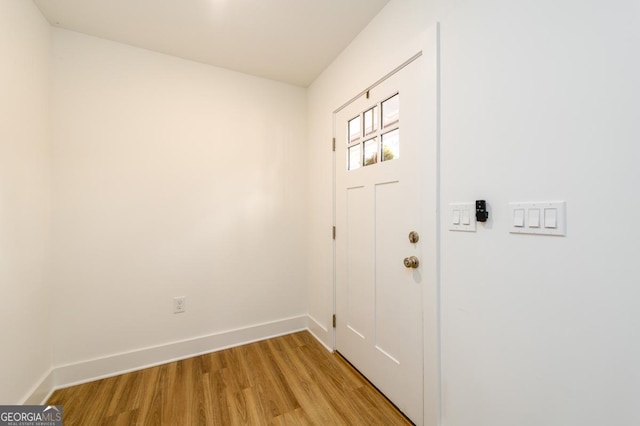 doorway with baseboards and light wood finished floors