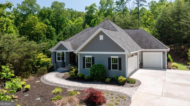 view of front facade with board and batten siding, concrete driveway, roof with shingles, and a garage