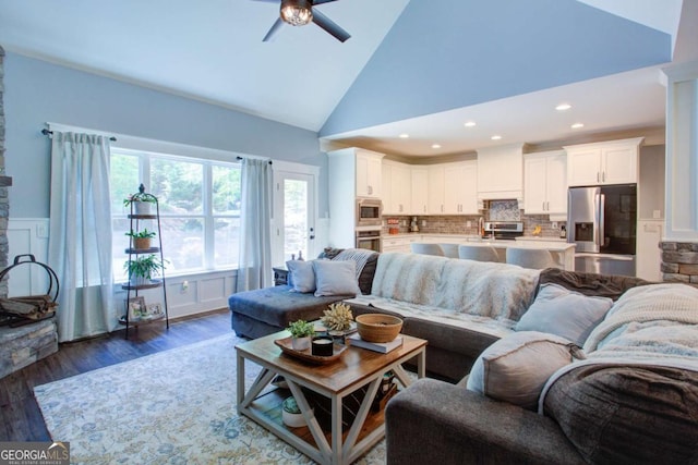 living room with ceiling fan, high vaulted ceiling, a wainscoted wall, recessed lighting, and dark wood-type flooring