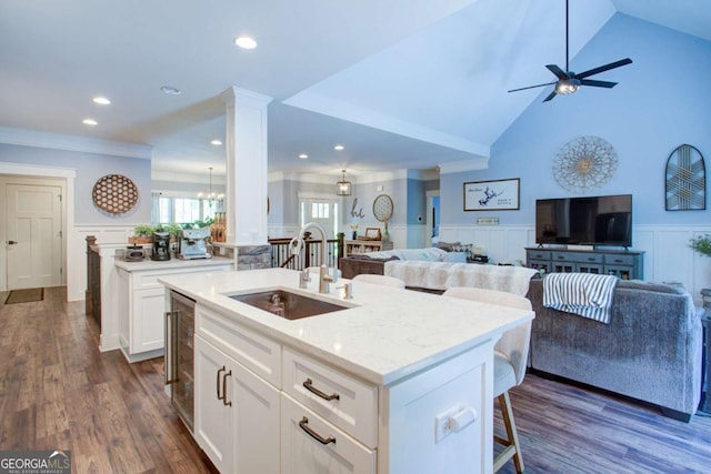 kitchen featuring a kitchen island with sink, open floor plan, and a sink