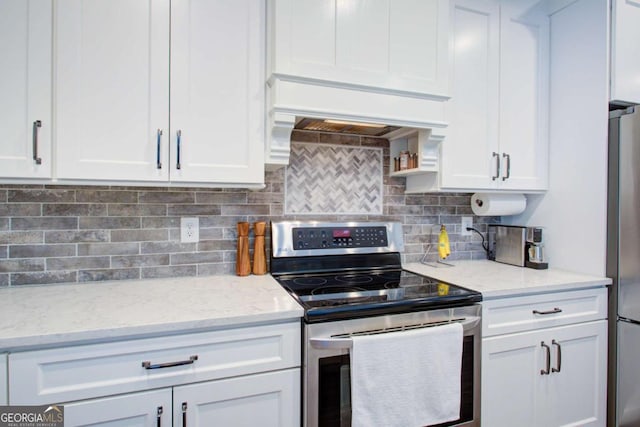 kitchen featuring light stone counters, decorative backsplash, stainless steel appliances, and white cabinetry