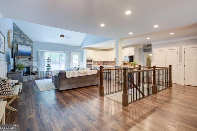 living room featuring ceiling fan, dark wood-type flooring, and lofted ceiling