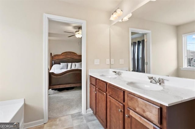 ensuite bathroom featuring double vanity, a sink, ceiling fan, and ensuite bath