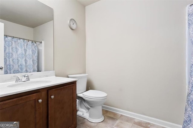 bathroom with baseboards, vanity, and toilet