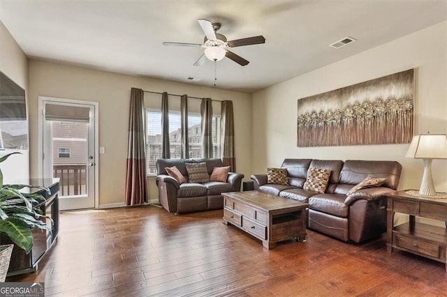 living room with ceiling fan, visible vents, and wood finished floors