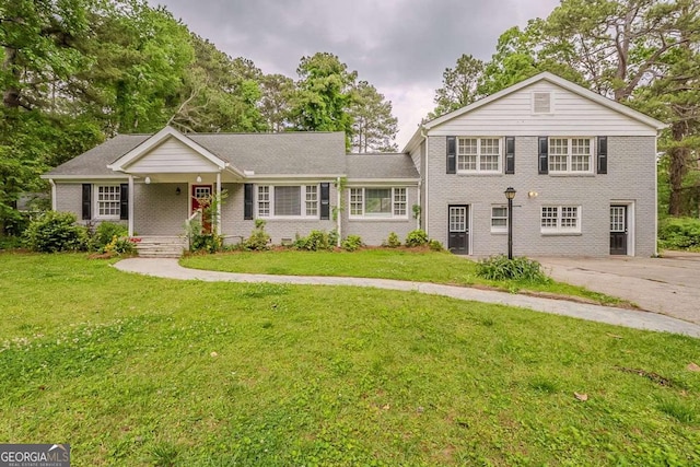 2465 Hogan Rd, Atlanta, GA 30344 - view of front facade featuring covered porch, brick siding, and a front yard