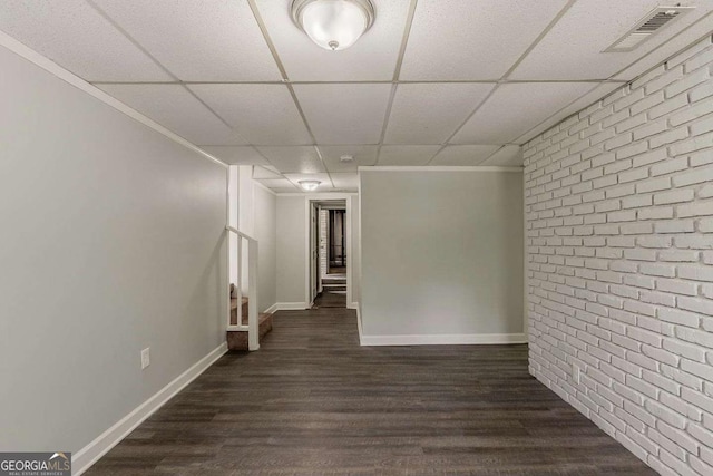 2465 Hogan Rd, Atlanta, GA 30344 - unfurnished room with dark wood-type flooring, brick wall, and a drop ceiling