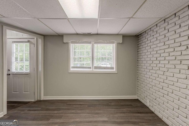 2465 Hogan Rd, Atlanta, GA 30344 - below grade area featuring a drop ceiling, dark wood-type flooring, and brick wall