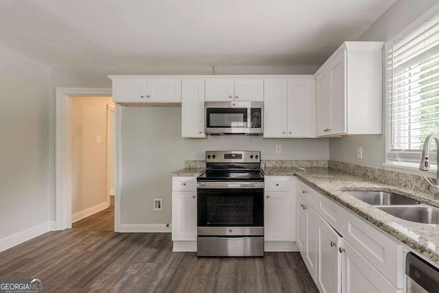 2465 Hogan Rd, Atlanta, GA 30344 - kitchen with appliances with stainless steel finishes, dark wood-type flooring, white cabinets, and light stone counters