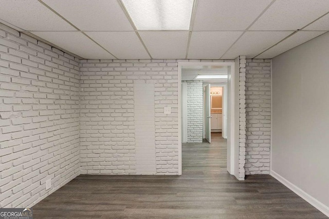 2465 Hogan Rd, Atlanta, GA 30344 - unfurnished room featuring brick wall, a paneled ceiling, and dark wood-style floors