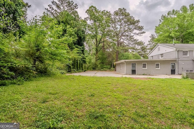 2465 Hogan Rd, Atlanta, GA 30344 - view of grassy yard featuring a patio area