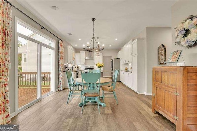 dining area featuring light wood-style floors, recessed lighting, baseboards, and a chandelier