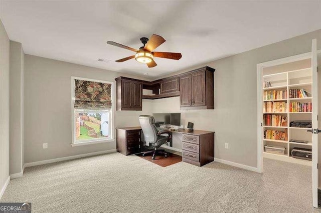 home office with baseboards, ceiling fan, light carpet, and visible vents