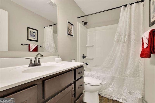 bathroom with toilet, shower / bath combination with curtain, and vanity