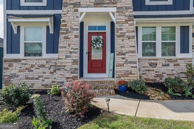 entrance to property with board and batten siding and stone siding