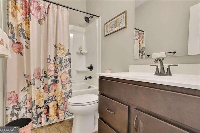bathroom featuring vanity, shower / bathtub combination with curtain, wood finished floors, and toilet