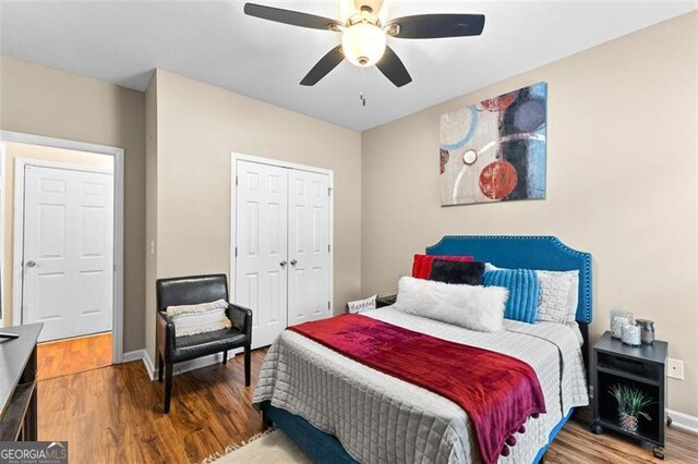 bedroom with baseboards, ceiling fan, wood finished floors, and a closet
