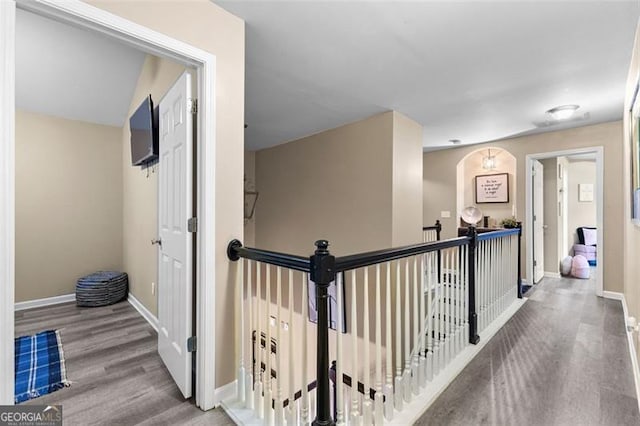 corridor featuring baseboards and wood finished floors