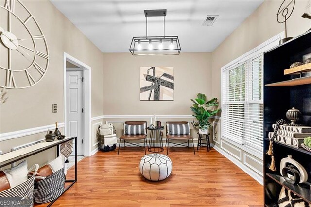 sitting room featuring visible vents and light wood-type flooring