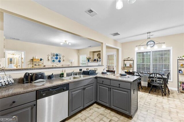 kitchen with a sink, gray cabinets, stainless steel dishwasher, and visible vents