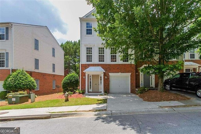 3990 Howell Park Rd, Duluth, GA 30096 - view of property with a garage, concrete driveway, and brick siding
