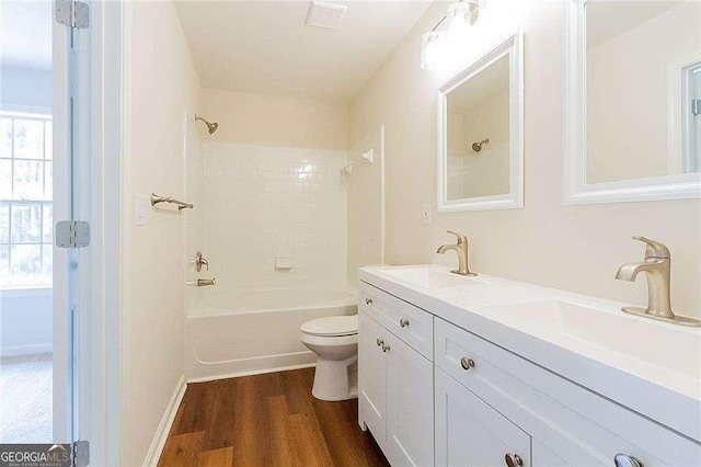 bathroom with toilet, shower / bath combination, a sink, and wood finished floors