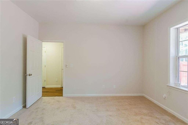 spare room featuring carpet floors, baseboards, and a healthy amount of sunlight