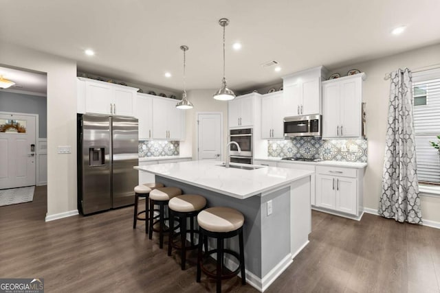 kitchen with a kitchen island with sink, visible vents, appliances with stainless steel finishes, a sink, and recessed lighting