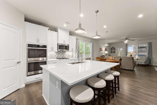 kitchen with visible vents, an island with sink, recessed lighting, a sink, and stainless steel appliances