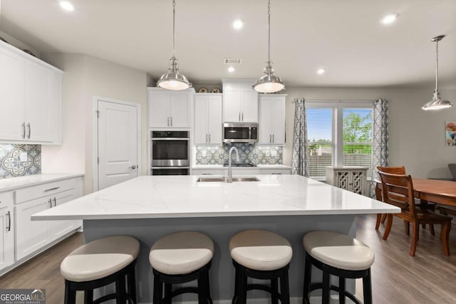 kitchen featuring visible vents, dark wood-type flooring, white cabinetry, a sink, and appliances with stainless steel finishes