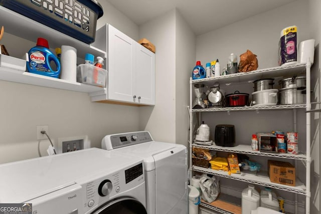 clothes washing area featuring cabinet space and washer and dryer