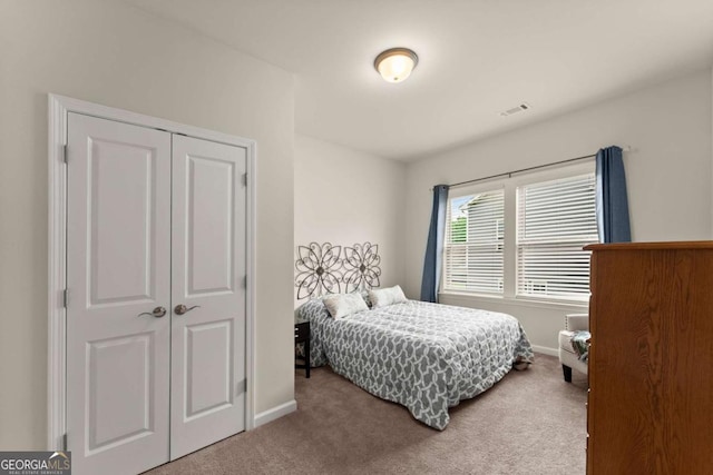 carpeted bedroom with baseboards, visible vents, and a closet