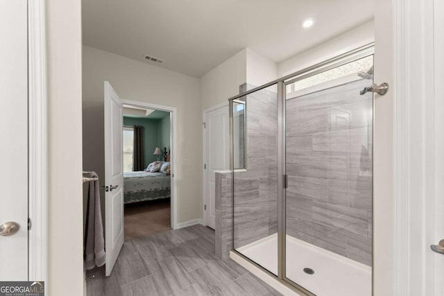 ensuite bathroom featuring connected bathroom, baseboards, visible vents, and a shower stall