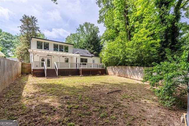 rear view of house featuring a deck, a fenced backyard, and a pergola