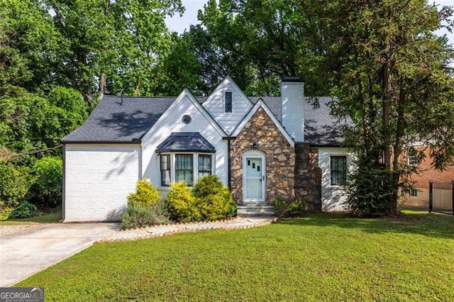 view of front of house featuring a chimney, stone siding, and a front yard