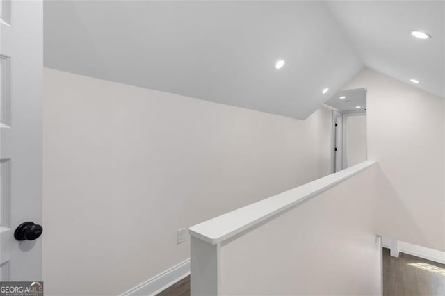 corridor with vaulted ceiling, baseboards, dark wood-style floors, an upstairs landing, and recessed lighting