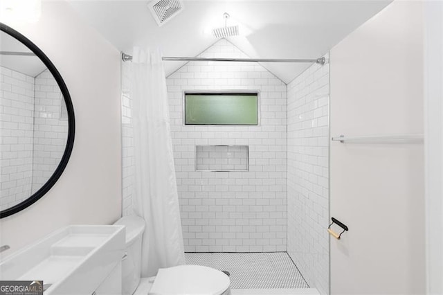 bathroom featuring vaulted ceiling, a stall shower, toilet, and visible vents