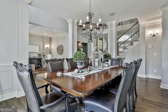 dining room with visible vents, decorative columns, wood finished floors, and a chandelier