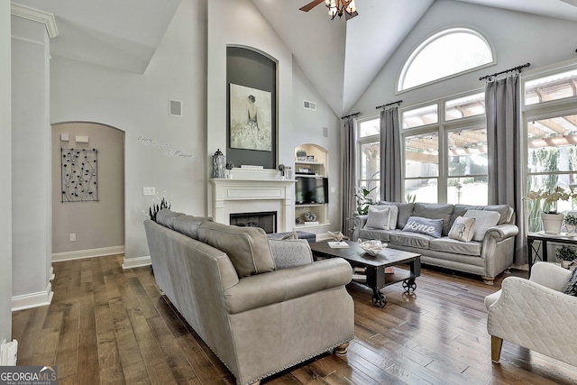 living room featuring a ceiling fan, visible vents, arched walkways, a fireplace, and high vaulted ceiling