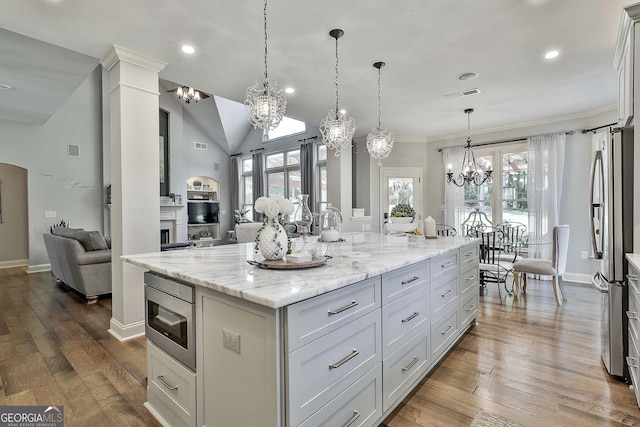 kitchen featuring visible vents, built in microwave, freestanding refrigerator, open floor plan, and an inviting chandelier