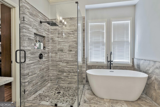 bathroom with a freestanding tub, a stall shower, tile walls, and a wainscoted wall