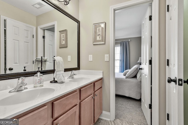 bathroom with visible vents, a sink, baseboards, and double vanity
